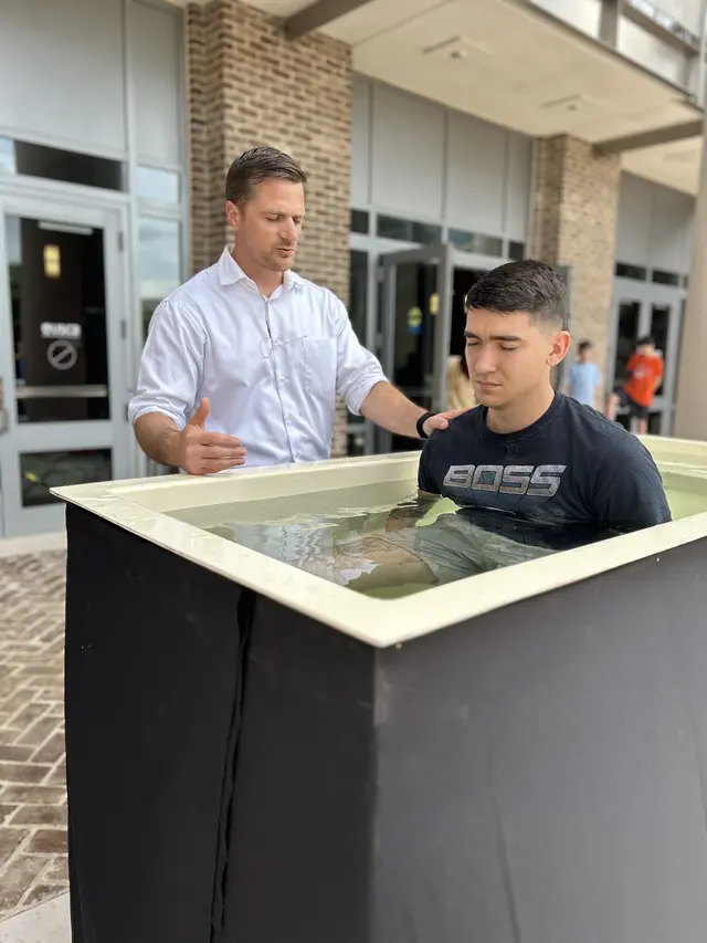 Pastor Daniel baptizing a young man in the baptistry outside the church entrance