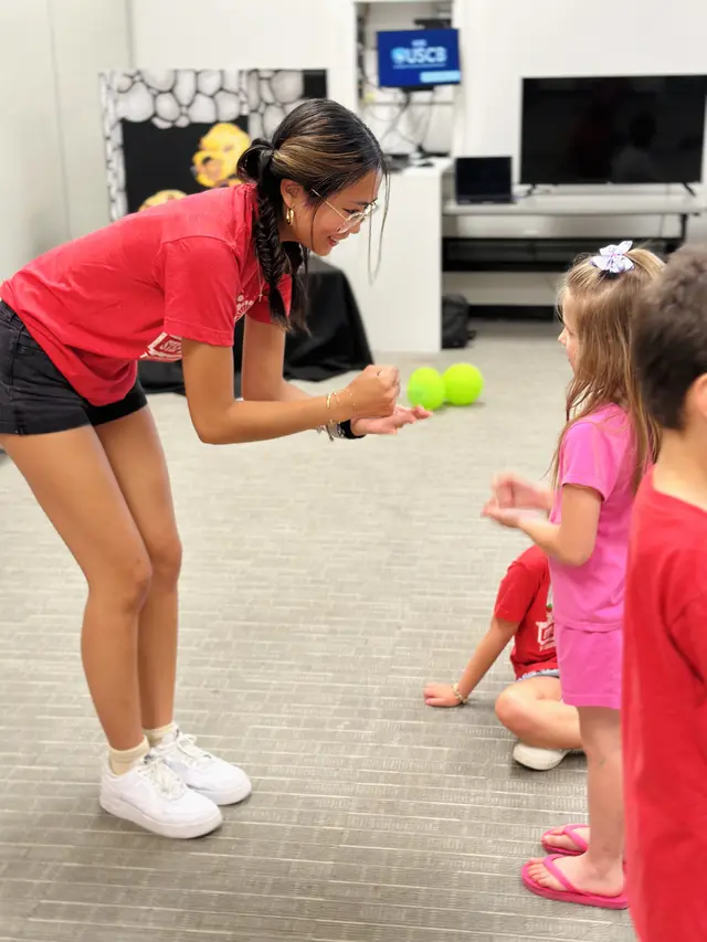 A Bridge Kids volunteer playing a ball game with young girls