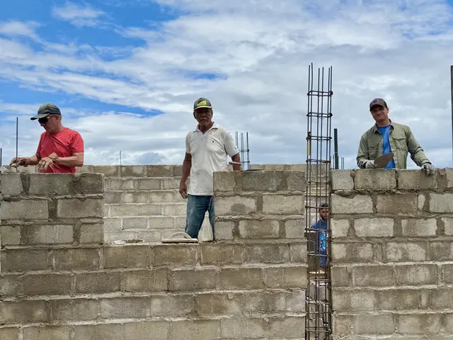 Local workers and team members raising the block walls of the new training center